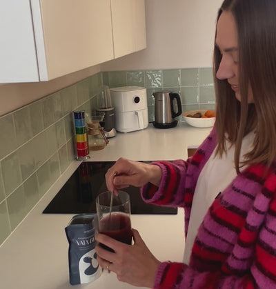 Mergina maišo stiklinėje Vata Blend mišinį ir jį išgeria
